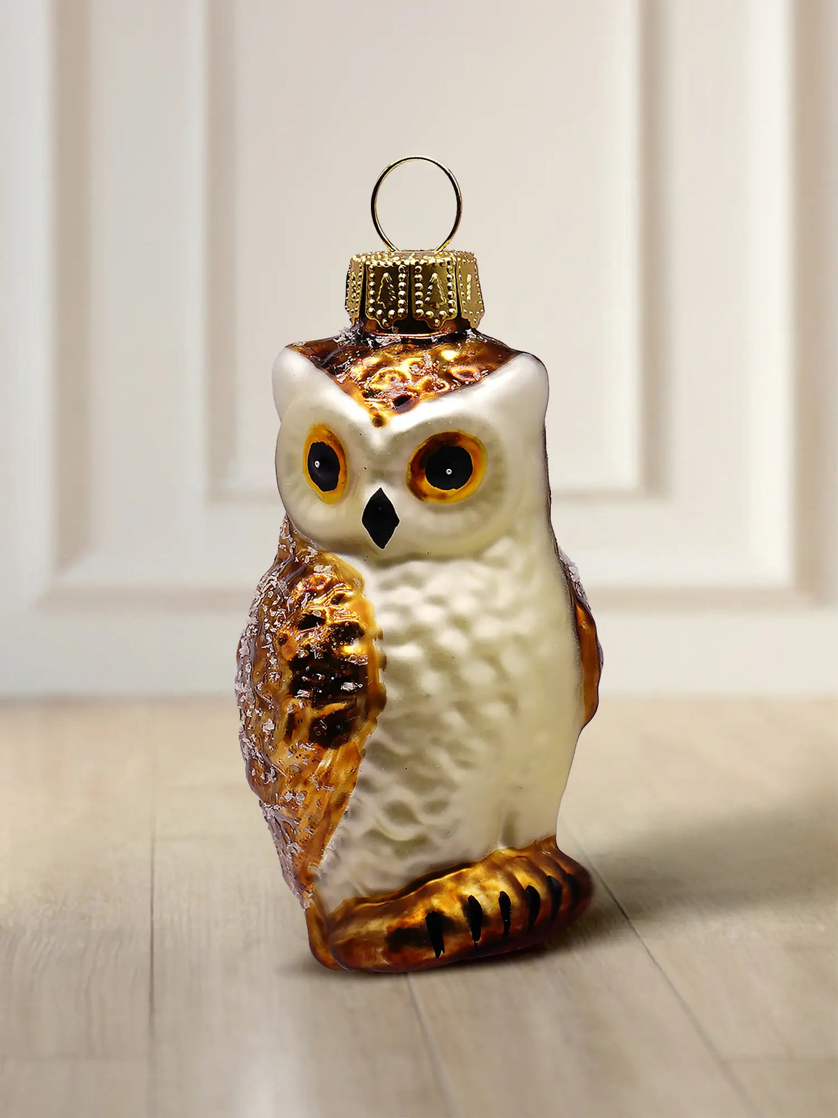 Glasfiguur uil: zittende uil met een crèmewitte borst, bruin-gouden vleugels, oranje ogen en een gouden ophangoog
