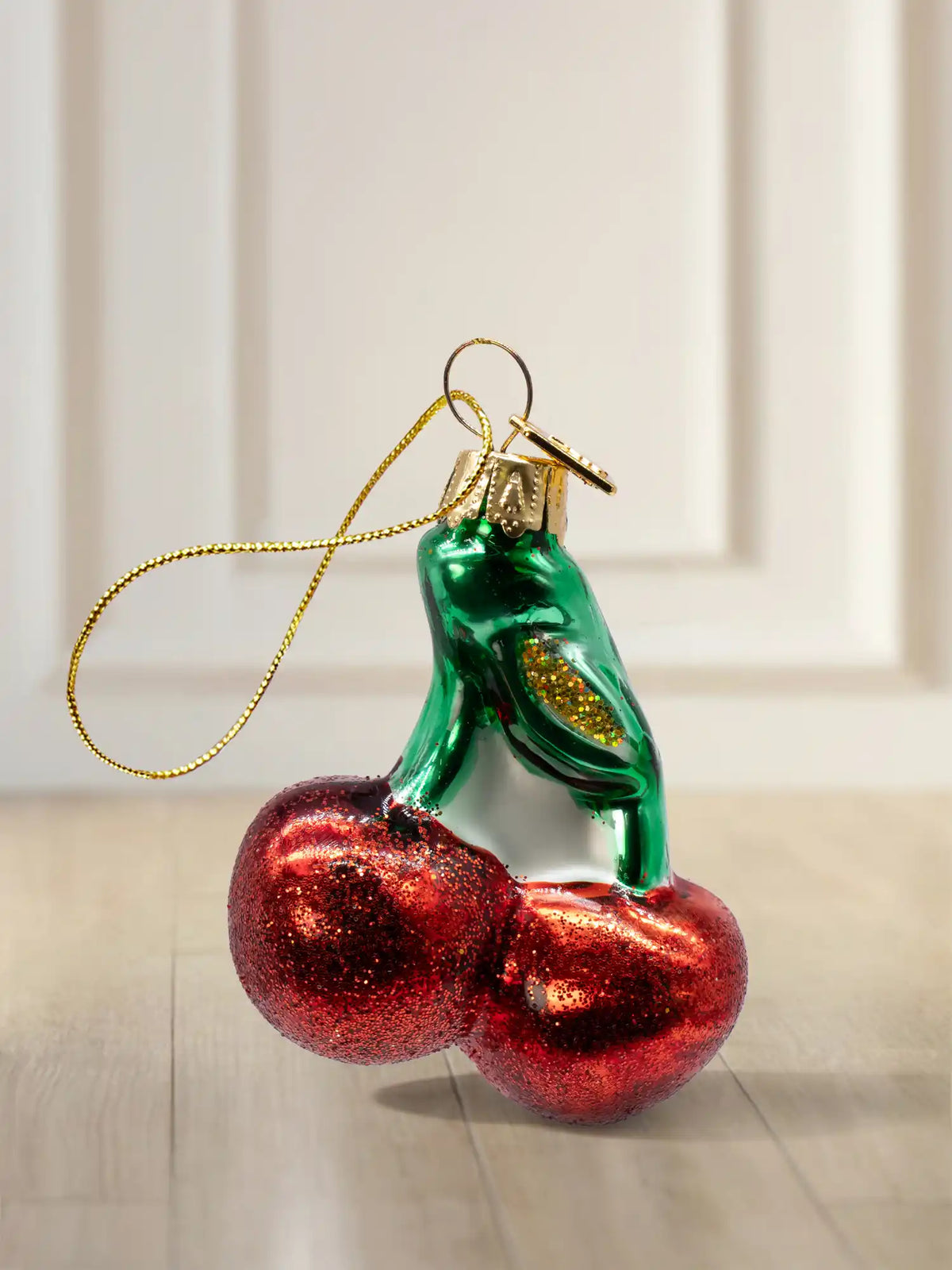 Glasornament Kirsche: zwei rote Kirschen mit grünem Stiel, roter Glitter-Finish, goldenes Hängeelement