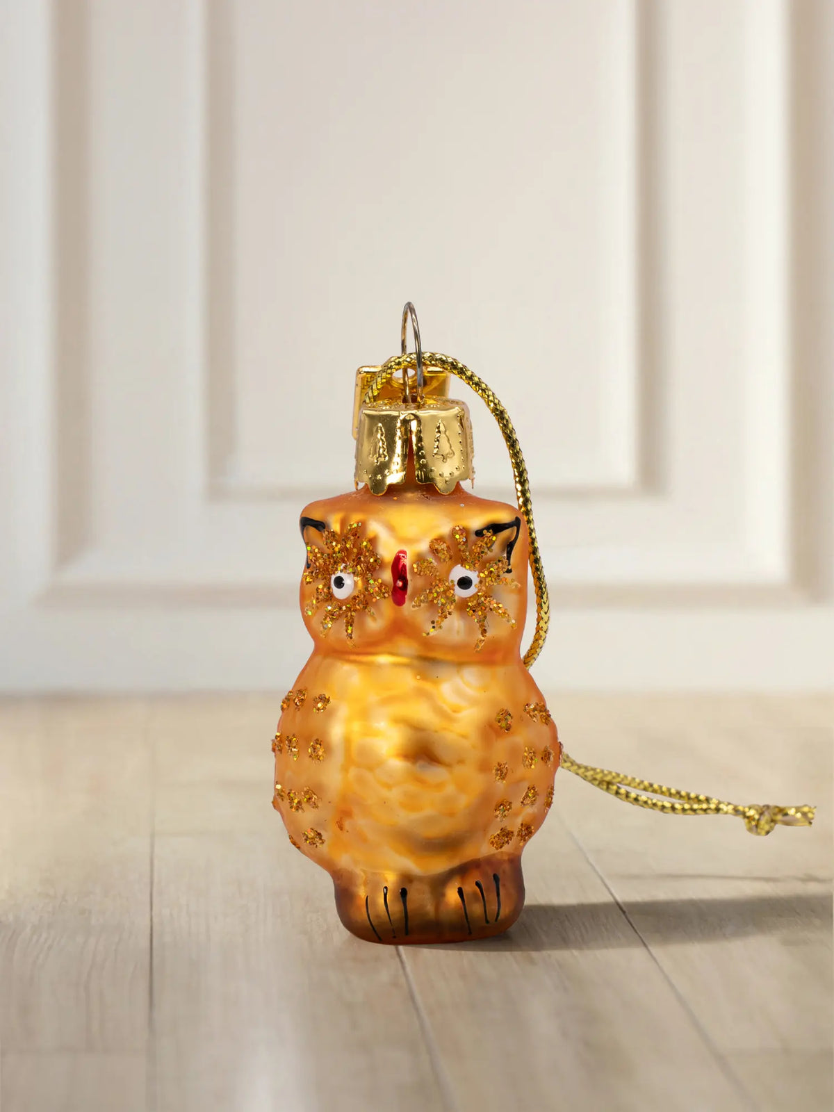 Glasornament Eule klein: runde goldorange Glasfigur mit Goldglitter-Augenringen, rotem Schnabel, goldenes Hängeelement