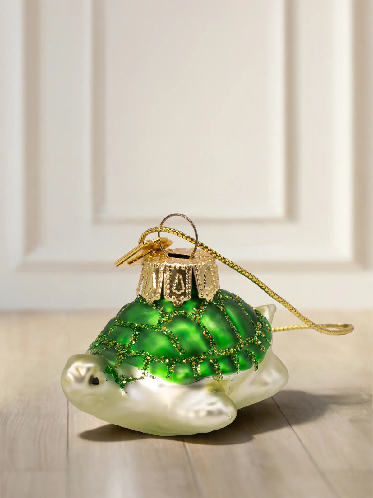 Glasornament Schildkröte: grüner Panzer mit Goldglitter-Abgrenzungen, weißlich-silberner Körper, goldenes Hängeelement