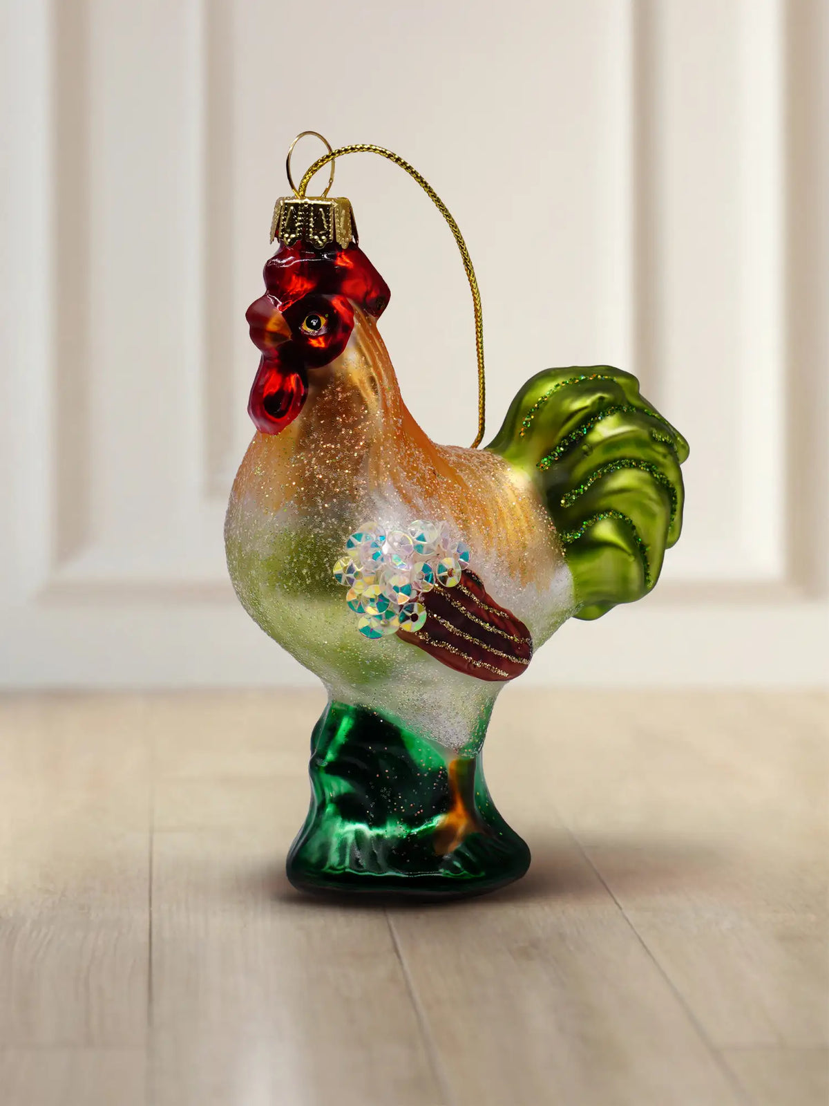 Glasornament Hahn: bunter Glashahn in Braun, Orange, Weiß und Grün mit rotem Kamm, irisierendes Paillettendetail an der Brust, goldener Aufhänger mit goldener Kordel