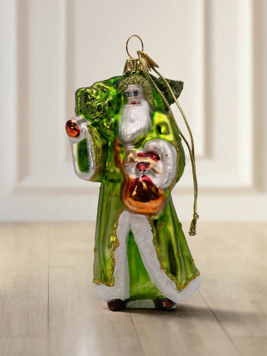 Glasornament Waldsanta: Santa in langem grünem Mantel mit weißem Fellbesatz und goldenen Glitzerdetails, hält einen kleinen Weihnachtsbaum, goldene Aufhängekappe