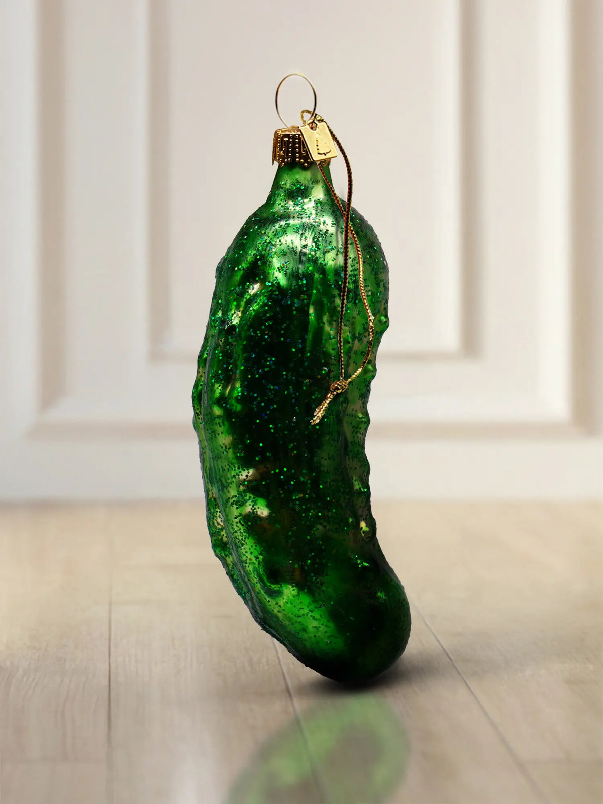 Glasornament Gurke groß: lange schlanke Glasgurke in dunklem Smaragdgrün mit feinem Glitter, goldener Aufhänger mit dunkelroter Kordel