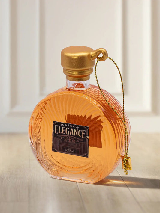 Glasornament Cognac-Flakon: runde Flasche mit bernsteinfarbenem Inhalt, goldenem Verschluss und Etikett „Maison Elegance Cognac 1884"