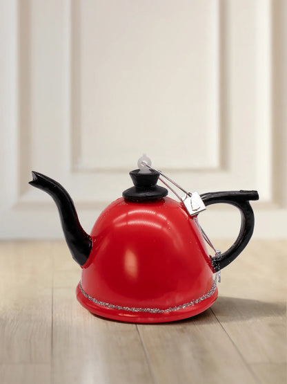 Glazen theepotornament: rode theepot met zwart handvat, schenktuit en dekselknop, zilveren glitterrand en zilveren koord