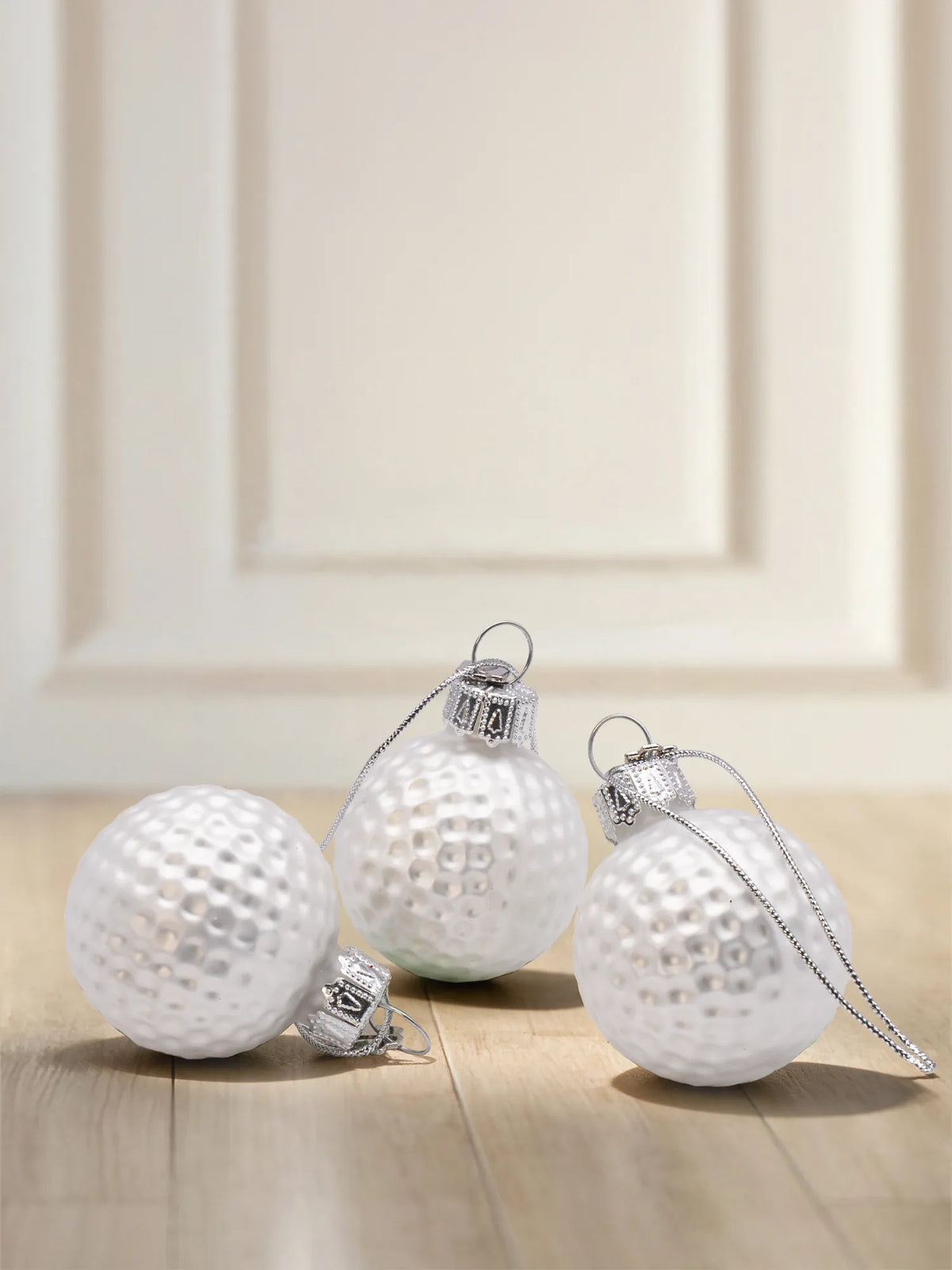 Glasornament Golfbälle: drei weiße Golfbälle mit Noppenstruktur und silbernen Aufhängekappen mit Kordel