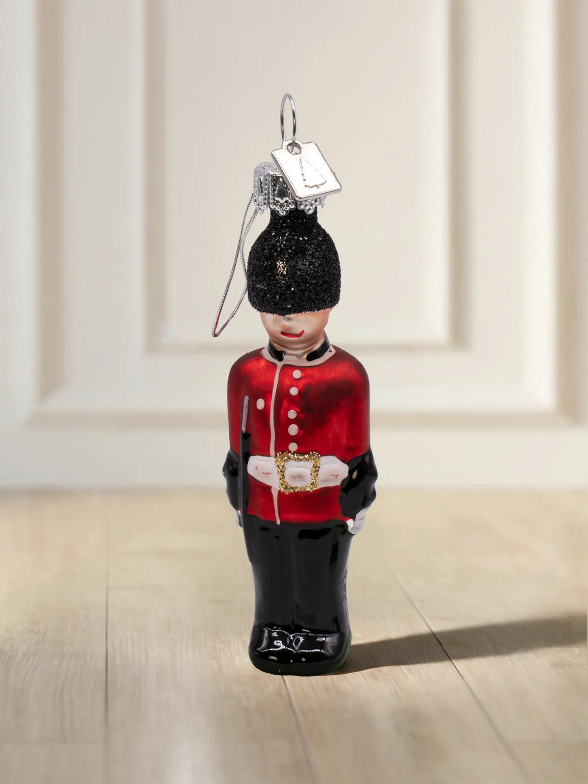 Glasornament Gardist: britischer Gardist in roter Uniform mit schwarzer Bärenfellmütze aus Glitzer und goldener Gürtelschnalle