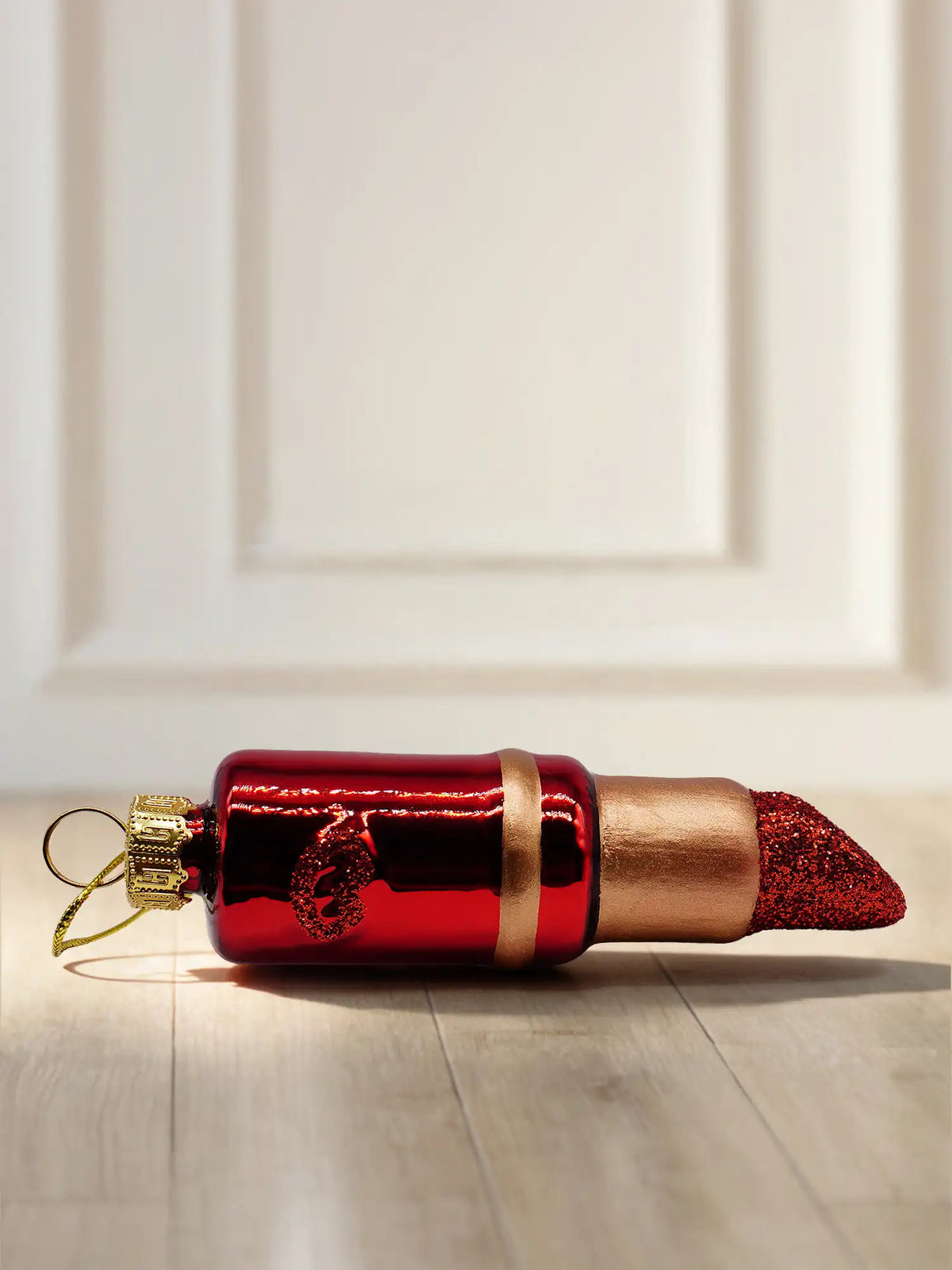 Glasornament Lippenstift: roter glänzender Lippenstift mit goldenem Ring und rotem Glitzerkopf, liegend, mit goldener Aufhängekappe und Kordel