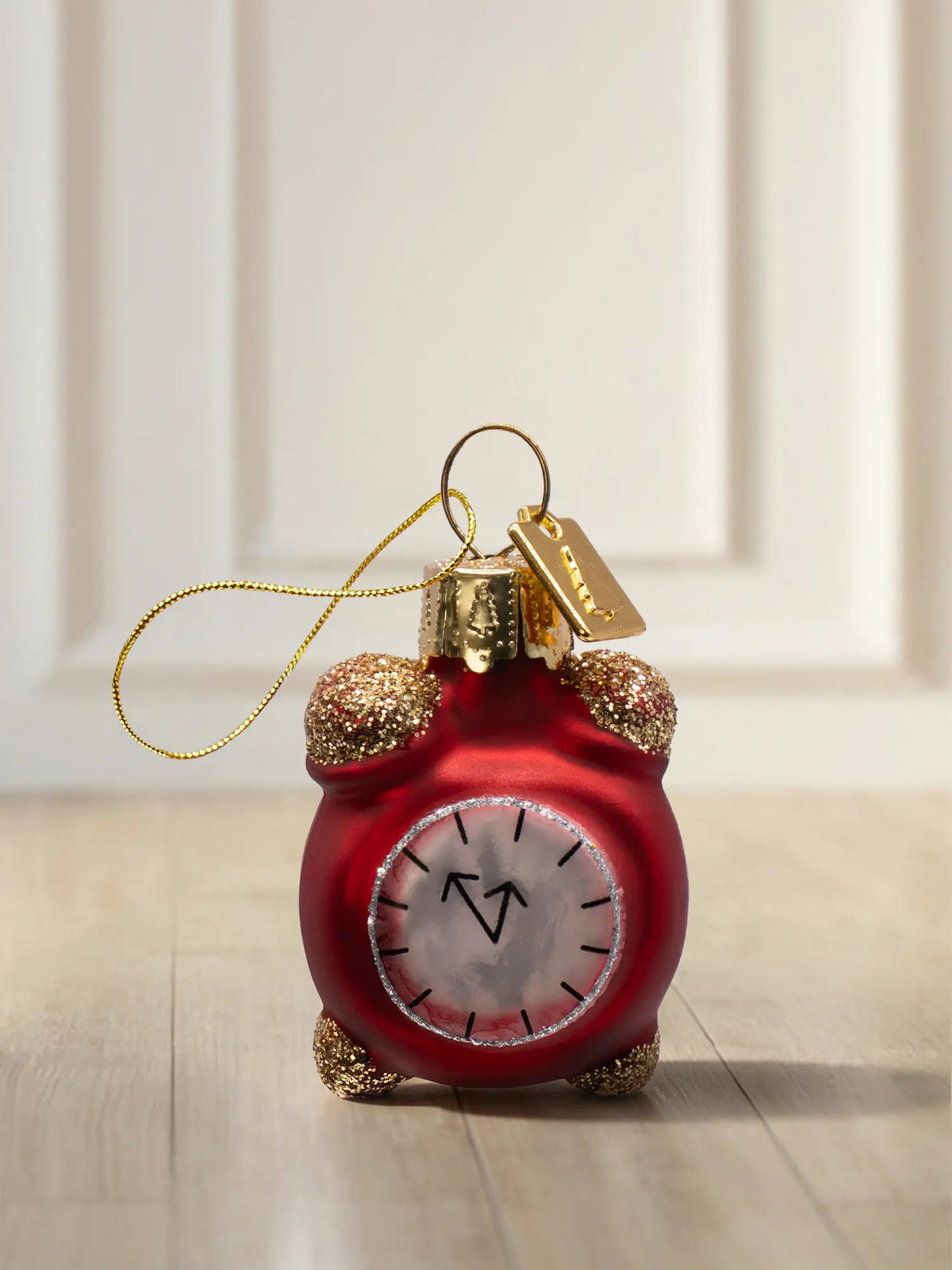 Glasornament Wecker: roter Wecker mit goldenen Glockenschellen, Zifferblatt kurz vor 12 Uhr, goldenes Hängeelement