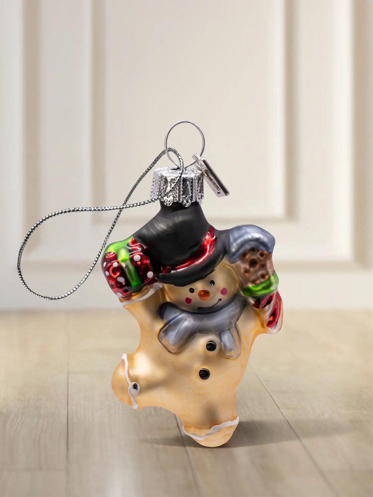 Glasornament Schneemann: Schneemann in Lebkuchenmann-Form, schwarzer Hut, grauer Schal, rote und grüne Handschuhe, silbernes Hängeelement