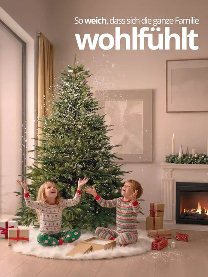 Kinder spielen unter einem künstlichen Weihnachtsbaum mit weißem Plüsch-Baumrock als festliche Weihnachtsdekoration.