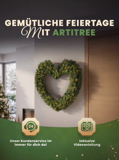 Couronne de Noël artificielle en forme de cœur avec éclairage LED, accrochée en décoration sur un mur clair dans un salon chaleureux