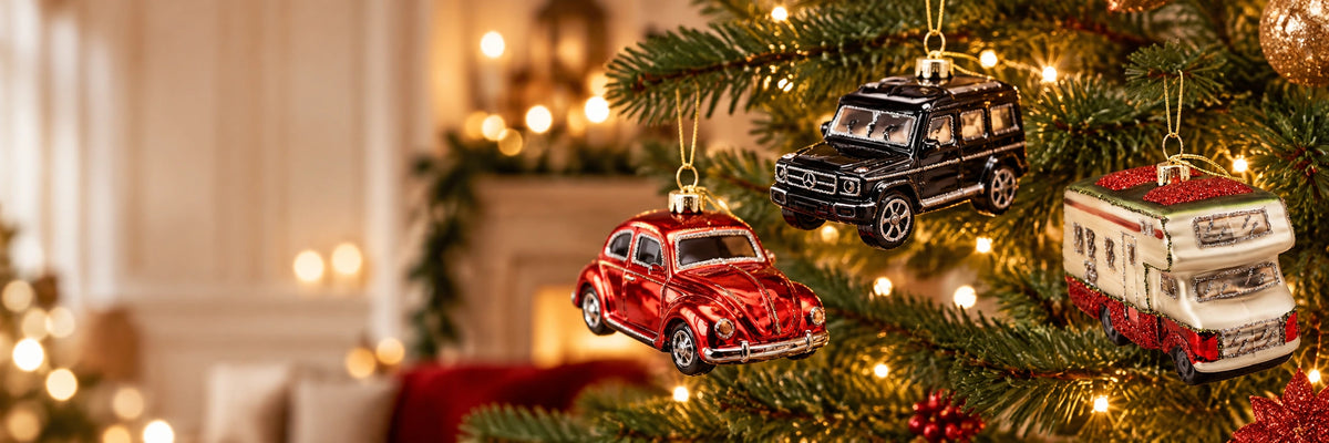 ArtiTree Glasfiguren Fahrzeuge: Roter VW Käfer, schwarzer Geländewagen und weißes Wohnmobil als Glasornamente am beleuchteten Weihnachtsbaum